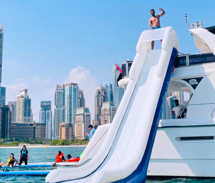Tourists play ride & slide on a yacht rental in Dubai