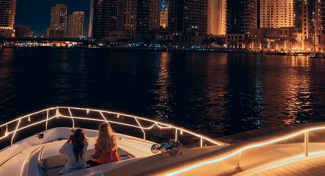Dubai Harbour Night Yacht Tour: Women Viewing Illuminated City Skyline